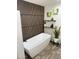Modern bathroom featuring a freestanding tub, wood accent wall, and stylish decor at 6719 S Hardy Dr, Tempe, AZ 85283