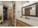 Bathroom featuring tile flooring, stone archway leading to shower, and wood cabinets at 6719 S Hardy Dr, Tempe, AZ 85283