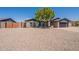 Charming single-story home with xeriscaped yard, complemented by mature tree and modern garage door at 6719 S Hardy Dr, Tempe, AZ 85283