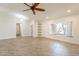Bright and airy living room featuring tile floors, ceiling fan, built-in shelving, and ample natural light at 6719 S Hardy Dr, Tempe, AZ 85283