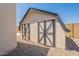 Backyard shed with traditional trim and painted door design, with neutral gravel surrounding it at 6719 S Hardy Dr, Tempe, AZ 85283