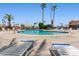 Community pool with ample lounge chairs, palm trees and shady areas, ready to relax at 701 S Dobson Rd # 203, Mesa, AZ 85202