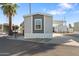 Manufactured home with covered parking and gravel landscaping under a clear blue sky at 701 S Dobson Rd # 203, Mesa, AZ 85202