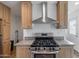 Updated kitchen featuring stainless steel stove with modern vent hood and wood cabinets at 701 S Dobson Rd # 203, Mesa, AZ 85202