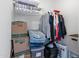Walk-in closet with clothes, storage boxes, and bins on the upper shelf and floor at 701 S Dobson Rd # 203, Mesa, AZ 85202