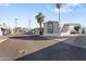 Manufactured home with a carport in a quiet neighborhood, with palm trees and blue skies at 701 S Dobson Rd # 203, Mesa, AZ 85202