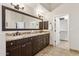 Bathroom featuring a large mirror, double sinks, granite counters and a linen closet at 7032 N 2Nd Ave, Phoenix, AZ 85021