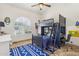 A bedroom featuring a bunk bed with desk, a large window, and tile floors at 7032 N 2Nd Ave, Phoenix, AZ 85021