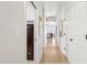 Bright hallway featuring light wood flooring and neutral paint leading to multiple rooms of the house at 7032 N 2Nd Ave, Phoenix, AZ 85021