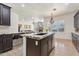 Open concept kitchen with hardwood floors, granite countertops, island bar, and views to living room at 7032 N 2Nd Ave, Phoenix, AZ 85021