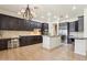 Modern kitchen with dark wood cabinets, granite countertops, stainless steel appliances, and eat-in island at 7032 N 2Nd Ave, Phoenix, AZ 85021
