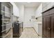 Laundry room featuring white cabinets and modern washer/dryer with a sink and tile floors at 7032 N 2Nd Ave, Phoenix, AZ 85021