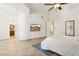Bright main bedroom with tiled floors, ceiling fan, decorative art, and ensuite bath at 7032 N 2Nd Ave, Phoenix, AZ 85021
