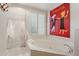 Bright bathroom features tub with tile surround and a window with plantation shutters at 7032 N 2Nd Ave, Phoenix, AZ 85021