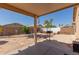 Spacious backyard featuring a stone patio, desert landscaping, and covered patio area at 716 E Horizon Heights Dr, San Tan Valley, AZ 85143