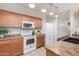 Well-lit kitchen boasts wooden cabinetry, white appliances, and tiled flooring at 716 E Horizon Heights Dr, San Tan Valley, AZ 85143