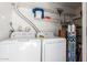 Functional laundry room featuring a white washer and dryer, plus ample shelving space for storage solutions at 830 S Dobson Rd # 86, Mesa, AZ 85202
