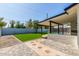 Manicured backyard featuring a covered patio, green lawn, and decorative stone pavers at 8602 N 42Nd Dr, Phoenix, AZ 85051