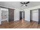 Bedroom with ceiling fan, wood-look floors, neutral walls, and sliding barn door to bath at 8602 N 42Nd Dr, Phoenix, AZ 85051