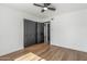 This bedroom features modern wood floors, ceiling fan, and a closet with black doors at 8602 N 42Nd Dr, Phoenix, AZ 85051
