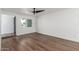 Bright bedroom featuring wood-look floors, a modern ceiling fan, and ample natural light from the window at 8602 N 42Nd Dr, Phoenix, AZ 85051