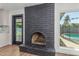 Living room with black brick fireplace and view of the backyard pool from the window at 8602 N 42Nd Dr, Phoenix, AZ 85051