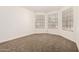 Bright bedroom featuring neutral carpeting, three windows, and freshly painted white walls at 8725 E Vía Del Arbor --, Scottsdale, AZ 85258