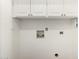White laundry room with connections for washer and dryer, and wall-mounted cabinets at 8725 E Vía Del Arbor --, Scottsdale, AZ 85258