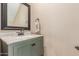 Powder room featuring a green vanity, marble top, and black framed mirror at 8939 W Villa Rita Dr, Peoria, AZ 85382