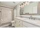Bathroom featuring a double sink vanity, framed mirror, and walk-in shower with decorative tile at 8939 W Villa Rita Dr, Peoria, AZ 85382