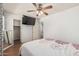 Bedroom with wood-look floors, ceiling fan, and doorway to closet and en suite bathroom at 8939 W Villa Rita Dr, Peoria, AZ 85382