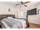 Bedroom with bed, ceiling fan, wall-mounted TV, and access to the Primary bathroom and closet at 8939 W Villa Rita Dr, Peoria, AZ 85382