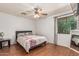Bright bedroom with wood-look flooring, ceiling fan, and window with blinds and curtains at 8939 W Villa Rita Dr, Peoria, AZ 85382
