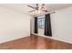 Spacious bedroom with wood-look floors, a ceiling fan, and a window with privacy blinds at 8939 W Villa Rita Dr, Peoria, AZ 85382
