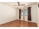 Empty bedroom features wood-look floors, ceiling fan, and windows with curtains and blinds at 8939 W Villa Rita Dr, Peoria, AZ 85382