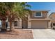 Two-story home with desert landscaping, attached two-car garage, and desert landscaping with palm trees at 8939 W Villa Rita Dr, Peoria, AZ 85382