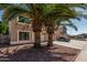 View of a two story home with desert landscaping, palm trees, and an attached two-car garage at 8939 W Villa Rita Dr, Peoria, AZ 85382