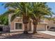 View of a two story home with desert landscaping, palm trees, and an attached two-car garage at 8939 W Villa Rita Dr, Peoria, AZ 85382