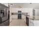 Modern kitchen with stainless steel appliances, white cabinetry, and an island with granite countertops at 8939 W Villa Rita Dr, Peoria, AZ 85382