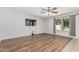 Open living room with wood-look floors, ceiling fan, and a view of the pool from the window at 8939 W Villa Rita Dr, Peoria, AZ 85382