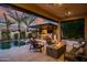 Inviting backyard featuring a sparkling pool, outdoor kitchen, fire pit, and comfortable seating area, perfect for entertaining at 9255 W Los Gatos Dr, Peoria, AZ 85383