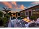 Relaxing backyard setting featuring a fire pit, comfortable chairs, swimming pool, and outdoor kitchen at 9255 W Los Gatos Dr, Peoria, AZ 85383
