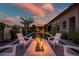 Cozy outdoor fire pit area with comfortable seating, perfect for relaxing evenings by the pool and outdoor kitchen at 9255 W Los Gatos Dr, Peoria, AZ 85383