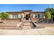 Stunning single-story home featuring a stone facade, desert landscaping, and an arched entryway at 9255 W Los Gatos Dr, Peoria, AZ 85383
