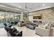 Spacious living room with stone fireplace, comfortable sofas, and large windows at 9255 W Los Gatos Dr, Peoria, AZ 85383