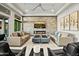Cozy living room features a stone accent wall, fireplace, comfortable sofas, and modern decor at 9255 W Los Gatos Dr, Peoria, AZ 85383