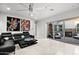 Stylish living room featuring a large leather couch, modern decor, and sliding glass doors to an outdoor seating area at 9255 W Los Gatos Dr, Peoria, AZ 85383