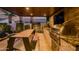 Stylish outdoor kitchen and dining area with a built-in grill, stone backsplash, and a modern dining table at 9255 W Los Gatos Dr, Peoria, AZ 85383