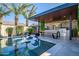 Backyard pool and outdoor kitchen including patio furniture under a covered entertainment area provides the perfect spot for entertaining at 9255 W Los Gatos Dr, Peoria, AZ 85383