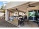 Spacious covered patio featuring comfortable seating, ceiling fans, and an outdoor cooking area, ideal for relaxation at 10068 E San Salvador Dr, Scottsdale, AZ 85258